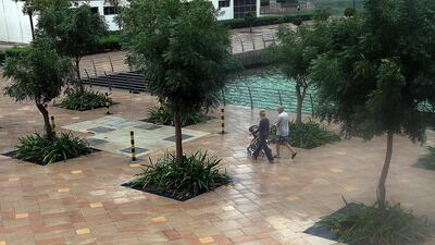 People enjoy the rainy weather at Jumeirah Lakes Towers in Dubai.