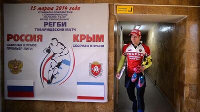 A Russia rugby union player walks past the poster advertising the match v Crimea rugby union in central Simferopol's stadium on Saturday. Filippo Monteforte / AFP / March 15, 2014