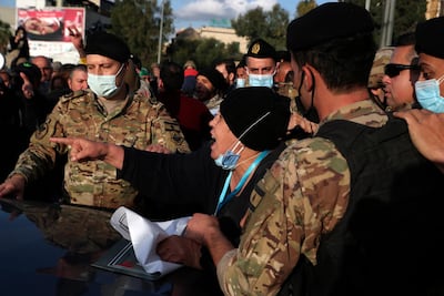 An anti-government protester argues with Lebanese soldiers as they try to open a main road that links the presidential palace, during a protest in Baabda, east of Beirut, March, 27.AP