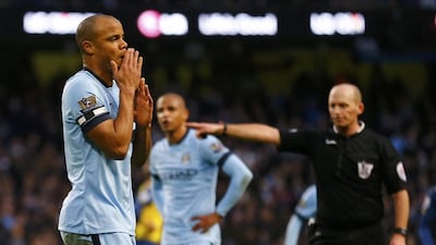 Manchester City captain Vincent Kompany, left, reacts after conceding a penalty, as referee Mike Dean points to the spot. Darren Staples/Reuters