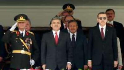 Gen Ilker Basburg, Turkey's new chief of staff, salutes as he stands next to Abdullah Gul, centre, the president, and Recep Tayyip Erdogan, the prime minister, right, during a military parade in Ankara.