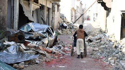 A boy pushes a wheelchair along a damaged street in the east Aleppo neighbourhood of Al Mashatiyeh on January 4, 2017. Bassam Diab/UNHCR/Handout via Reuters