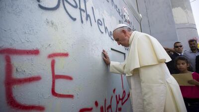 Pope Francis touches the wall that separates Israel from the West Bank on his way to celebrate a mass in the Manger Square next to the Church of the Nativity, believed by many to be the birthplace of Jesus Christ, in the West Bank city of Bethlehem on Sunday. EPA / Osservatore Romano
