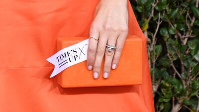 Actress D'Arcy Carden holds a tag reading 'Time's Up' referring to sexual harassment scandals in the movie industry and beyond. AFP