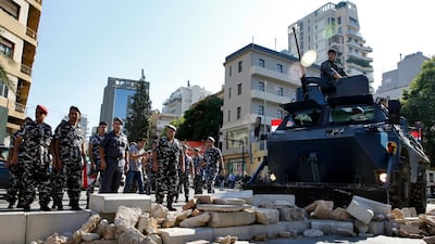 Police remove stones set up by anti-government protesters to block a main road in Beirut. AP