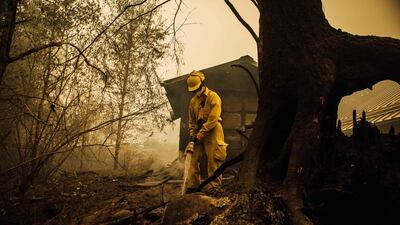 Volunteer firefighter Jacob Ruthrock puts out embers from a fire in Gates, Oregon. AFP
