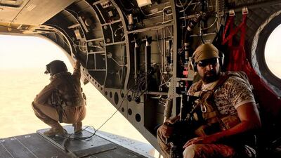 A soldier and an airman from the UAE sit in a chinook helicopter flying to the front line conflict zone of Marib in central Yemen on September 14, 2015. Gulf Arab coalition forces fighting Houthi militia in Yemen are advancing on the capital in a two-pronged offensive, generals say. Noah Browning/Reuters