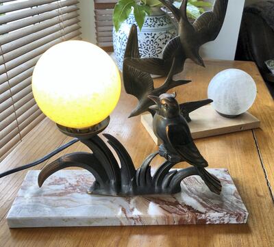 A pair of early 20th-century bird globe lamps on marble plinths for under Dh200