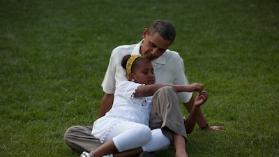 Mr Obama sits on the grass with daughter Sasha during a barbecue with family and friends in celebration of his 49th birthday on the South Lawn of the White House. Photo courtesy of the National Archives
