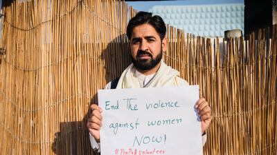 A campaigner holds a placard to raise awareness of violence against women in Afghanistan.