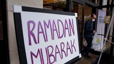 A volunteer helps hand out part of some 650 hot meals at a meal donation drive-thru at Dar Al-Hijrah Islamic Center in Falls Church, Virginia, USA. EPA