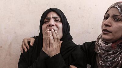 A Palestinian mother (L) of three children from Abu Hindi family mourns during their funeral, in Al Shateaa refugee camp in the west of Gaza City. Mohammed Saber / EPA