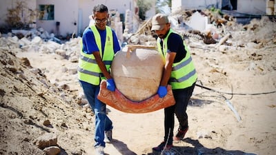Members of the Heritage Guardians Team carry an earthenware container recovered in Khan Younis, southern Gaza. Photo: Mohammed Abu Doon