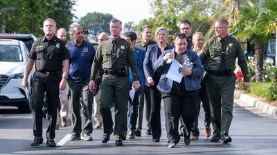 Police officers arrive at a press conference after the shooting, which also left four people critically injured. AFP