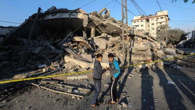 Palestinian children stand in front of a damaged building in Gaza City. AFP Photo