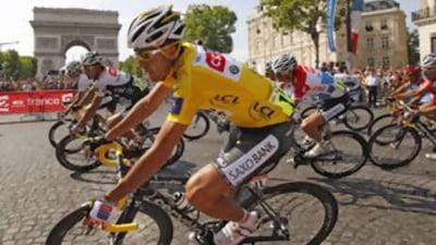 The Tour de France winner Carlos Sastre of Spain wears the leader's yellow jersey as he cycles past the Arc de Triomph on the Champs-Elysees.