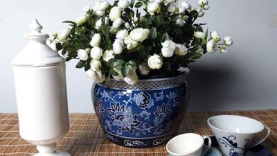 Blue pot Dh855 at Sia, flowers Dh145 at Sia, large cup Dh59 at Crate & Barrel, dark blue saucer Dh39 at Crate & Barrel, Jar Dh415 at Flamant, small cup and saucer Dh145 at Flamant.