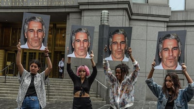 In this 2019 file photo, a protest group called Hot Mess hold up photos of Jeffrey Epstein outside of the Federal courthouse in New York City. AFP