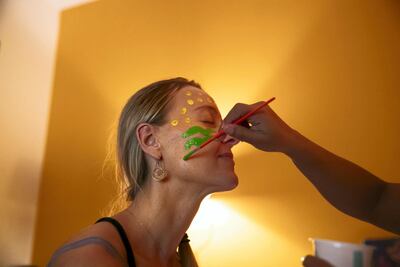 Laura Maciunaite has her body painted by Tatiana Moreno, and they are told to let the body inform the art. Reem Mohammed / The National