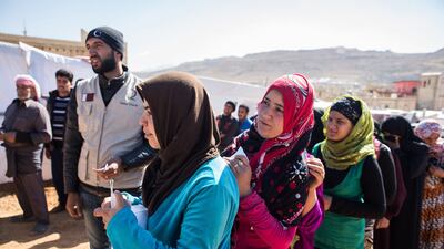 A picture taken on October 25, 2014, shows Syrian refugees waiting for food aid parcels from a non-governmental organisation in Al Masri refugee camp near the eastern Lebanese town of Arsal. Maya Hautefeuille/AFP Photo
