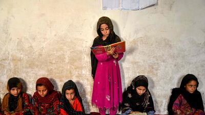 An Afghan girl reads a religious book at an Islamic school in the Spin Boldak district of Kandahar. AFP