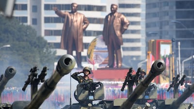 Korean People's Army (KPA) soldiers salute as they ride tanks during a military parade and mass rally on Kim Il Sung square in Pyongyang. AFP