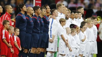 England’s Wayne Rooney, centre, shown during the playing of the national anthems before the Euro 2016 qualifying match against Switzerland on Tuesday. Frank Augstein / AP