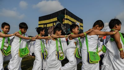 Malaysian Muslim boys circumambulate a mockup of the Kaaba, Islam's most sacred structure located in the holy city of Mecca, during an educational simulation in Shah Alam.