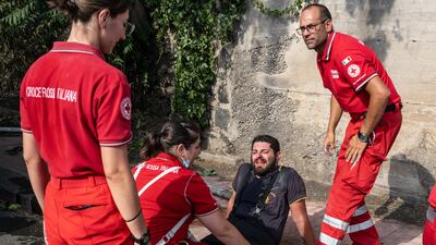 A fireman experiences breathing difficulties after putting out several fires and receives treatment from Red Cross volunteers in Catania, Italy. Getty