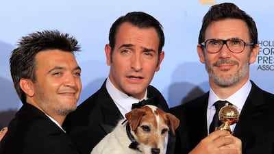 Producer Thomas Langmann (L), actor Jean Dujardin (C), winner of the best performance by an actor in a motion picture - comedy or musical, and director Michel Hazanavicius pose backstage with Uggie the dog, after "The Artist" won the best comedy or musica???