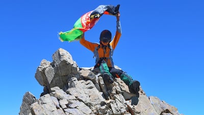 Zabih Afzali holding the Afghanistan flag having submitted Mount Shah Fuladi, June 2020. Courtesy Zabih Afzali