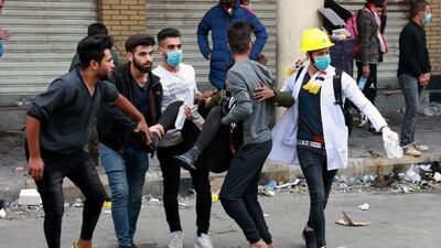 Iraqi protesters help their fellow protestor, who was wounded during clashes with riot police forces, following a protest at Al Rasheed street in central Baghdad. EPA