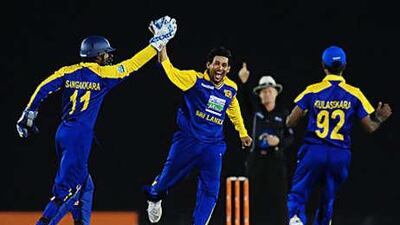 Sri Lankan cricketer Tillekeratne Dilshan, centre, celebrates with captain Kumar Sangakkara, left, and Nuwan Kulasekara after the dismissal of Mohammad Ashraful.