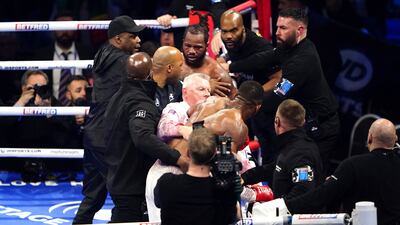 Anthony Joshua is pulled away by referee Marcus McDonnell after clashing with Jermaine Franklin and a member of Franklin's coaching staff after a heavyweight boxing match at The O2. AP