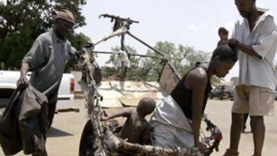 A woman suspected of cholera is helped to stand upon arrival at a clinic in Harare.