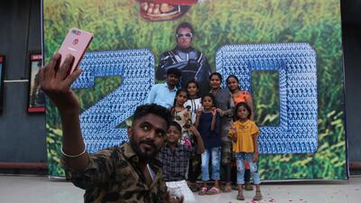 A fan takes selfie with his family next to a poster before the screening. AP Photo