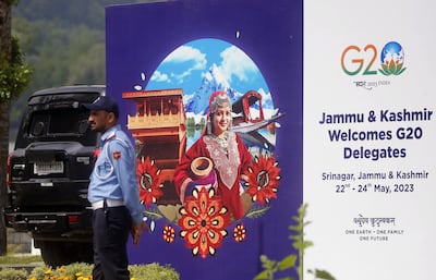 A police officer stands near a G20 hoarding in Srinagar, India-administered-Kashmir. EPA