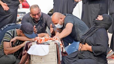 An Iraqi family mourns a relative who died of coronavirus during a reburial ceremony at the vast Wadi Al Salam cemetery in the Shiite holy city of Najaf on September 11, 2020. AFP