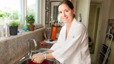 Julie Woods washes the vegetables over a dish to hold water that will be used later to water plants at her Dubai villa.