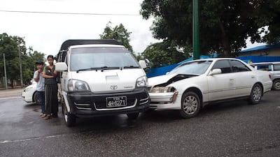 Two vehicles sit in the middle of the road after being involved in a collision in Yangon. Romeo Gacad / AFP