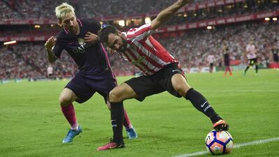 Barcelona’s Lionel Messi, left, duels for the ball with Athletic Bilbao’s Mikel Balenziaga. Alvaro Barrientos / AP Photo