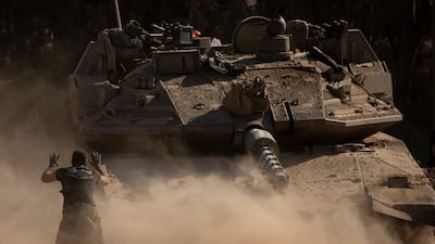 An Israeli soldier directs a tank near the border with Gaza. Getty Images