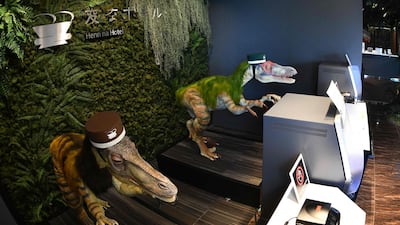 A pair of robot dinosaurs wearing bellboy hats welcome guests from the front desk at the Henn-na Hotel. AFP