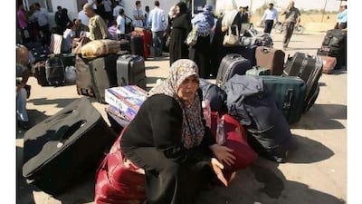 A Palestinian woman waits to cross into Egypt at the Rafah border crossing in the southern Gaza Strip yesterday. Ibraheem Abu Mustafa / Reuters