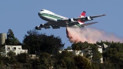 US Evergreen 747 supertanker sprays over a burning area in Ein Hod, Israel. Dozens of planes from around the world are now helping to fight the blaze.