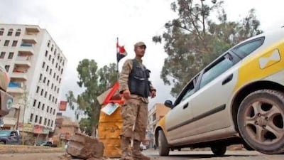 A policeman guards a checkpoint in the Yemeni capital Saana as security was stepped up after warnings that Al Qaeda may stage attacks. Mohammed Huwais / AFP