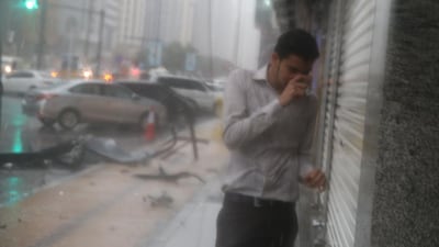 A man seeks shelter as heavy rain and strong winds hammer Abu Dhabi. Delores Johnson / The National