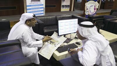 A traders at the floor of Dubai Financial Market today holds an Arabic newspaper with the headline reading "4.5 BIllion Profits in Local Stocks". Reem Mohammed/ The National