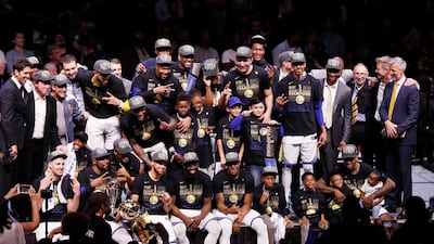 Golden State Warriors players pose for pictures with the NBA Finals trophy. David Maxwell / EPA