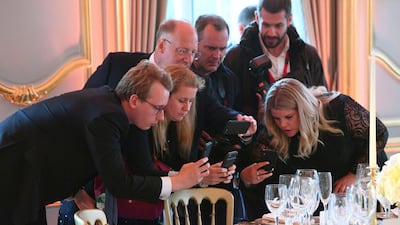 Journalists take photos of place settings for the Return Dinner at Winfield House, the residence of the Ambassador of the United States of America to the UK, in Regent's Park, London. AP